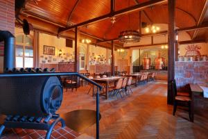 a restaurant with wooden floors and tables and chairs at Landhotel & Brauhaus Prignitzer Hof in Pritzwalk