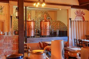 a restaurant with tables and chairs and a mirror at Landhotel & Brauhaus Prignitzer Hof in Pritzwalk