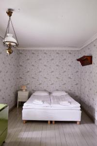 a bedroom with a bed and a wall with wallpaper at Taattisten Tila - Taattinen Farm and Cottages in Naantali