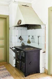 an old stove in a kitchen with white tiled walls at Taattisten Tila - Taattinen Farm and Cottages in Naantali