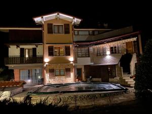una casa grande con piscina frente a ella por la noche en Nidi del faggio rosso - Family Holiday Home en Maresca