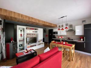 a living room with a red couch and a kitchen at Nidi del faggio rosso - Family Holiday Home in Maresca