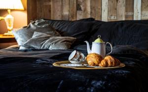 einen Teller Croissants und einen Wasserkocher auf dem Bett in der Unterkunft BOHOTEL in Macclesfield
