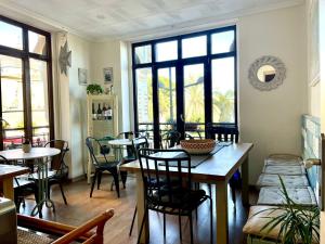 Un comedor con mesas y sillas y ventanas. en Balcón Al Mar, en Valencia