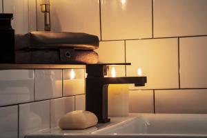 a bathroom sink with a faucet and a towel at BOHOTEL in Macclesfield