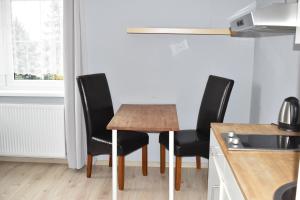 a kitchen with a wooden table and four chairs at Hostel Przed Świtem in Gorzów Wielkopolski
