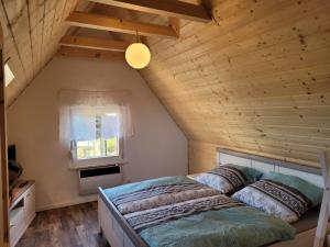 a bed in a room with a wooden ceiling at Ferienhaus Unstrutblick in Kaiserpfalz