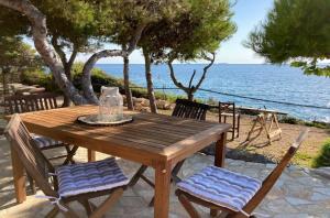 uma mesa e cadeiras de madeira com vista para o oceano em Kamaroules Sea Front em Argostoli