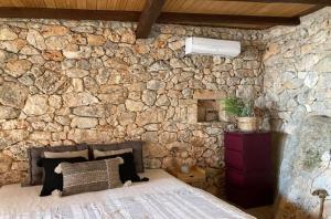 a stone wall with a bed in a room at Kamaroules Sea Front in Argostoli