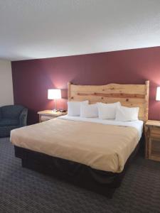 a bedroom with a large bed and a purple wall at Ramada by Wyndham Butte in Butte