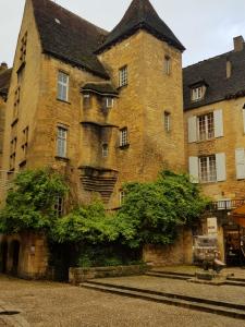 a large brick building with trees in front of it at Hôtel Confort Le Moulin Rouge in Terrasson-Lavilledieu +22 photos