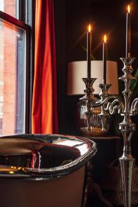 a bathroom with a sink and two candlesticks and candles at BOHOTEL in Macclesfield