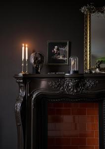 a fireplace with two candles on top of it at BOHOTEL in Macclesfield