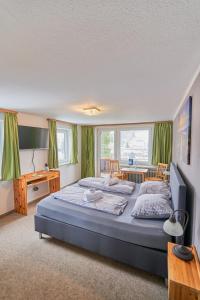 a bedroom with a large bed with green curtains at Landhotel Krone in Oberreute