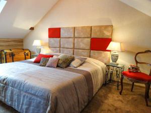 a bedroom with a large bed and a red headboard at La Maison Fleurie in Dieffenbach-au-Val