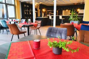 un restaurant avec des tables, des chaises et des nappes rouges dans l'établissement Sport Hotel Kenzingen, à Kenzingen