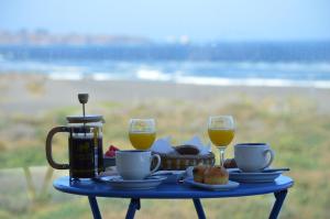 a blue table with a tray of food and two glasses of orange juice at Esfera Pichilemu - Lodge in Pichilemu