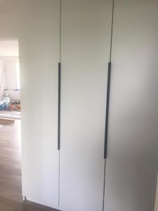 a white cabinet with two doors in a kitchen at Apartment Tarasy centrum in Siemiatycze