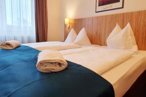 - une chambre d'hôtel avec 2 lits et des serviettes dans l'établissement Sport Hotel Kenzingen, à Kenzingen