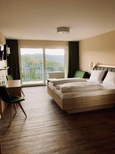 a bedroom with a large bed and a large window at Berg-Gasthof Hötzelein in Kunreuth +28 photos