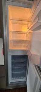 an empty refrigerator with its door open and its at Beautiful 2-bed Apartment on Torquay seafront in Torquay