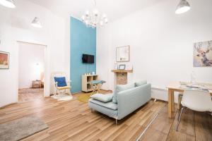 uma sala de estar com um sofá azul e uma mesa em BpR Rainbow Design Apartment-Superior em Budapeste