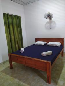 a bed in a room with green curtains at Janaka's House in Dickwella