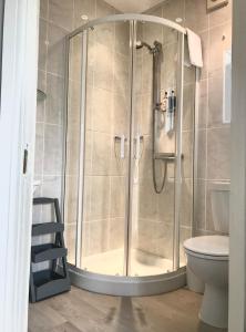 a shower with a glass door in a bathroom at Arbour House B&B in Swanage