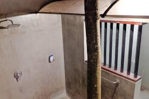 a bathroom with a staircase and a wall with a pole at Calm House - Nature inspired private stay Mirissa in Mirissa