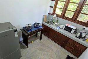 Calm House - Nature inspired private stay Mirissa في ميريسا: مطبخ مع كونتر ومغسلة وميكروويف