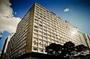 a large tall building with a tree in front of it at Comodidade e Segurança no Centro in Belo Horizonte