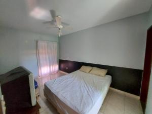 a bedroom with a bed and a flat screen tv at Saquarema - Condomínio Residencial Iate hotel. in Saquarema