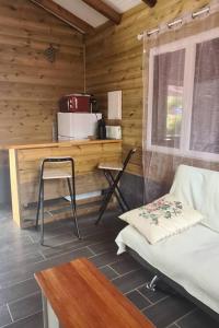 a room with a table and a chair in a cabin at Magnifique maison en bois avec piscine in Sainte-Anne