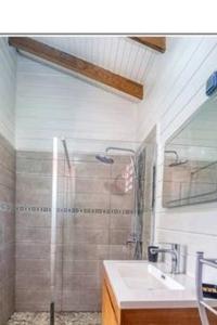 La salle de bains est pourvue d'une douche et d'un lavabo. dans l'établissement Magnifique maison en bois avec piscine, à Sainte-Anne