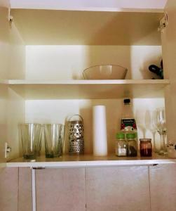 a shelf with bowls and other kitchen items on it at DEPARTAMENTO EN COMPLEJO RESIDENCIAL in Godoy Cruz