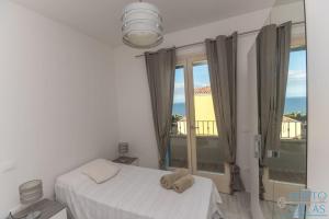Marina House - Luxury apartment, sea view, WI-FI, Aircon - Key to Villas في كاستيلساردو: غرفة نوم بسرير ونافذة كبيرة
