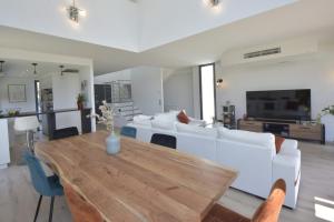 sala de estar con sofá blanco y mesa de madera en Contemporary Villa Swimming Pool & Jacuzzi, en La Roquette-sur-Siagne