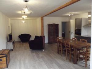a dining room and living room with a table and chairs at Le Playon, classification 3 étoiles in Lus-la-Croix-Haute