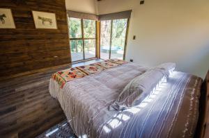 ein großes Bett in einem Zimmer mit Fenster in der Unterkunft cabaña con tinaja en viña narbona wines in Quillota