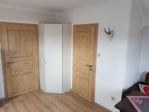 an empty room with two doors and wooden floors at Ferienwohnung Weber Alpenglück in Lechbruck