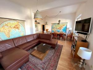 a living room with a brown leather couch and a tv at Helle 3-Zimmerwohnung in Uninähe in Braunschweig