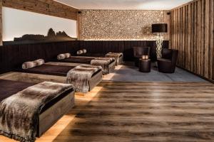 a room with four beds and a table at ArtHotel Anterleghes - Gardenahotels in Selva di Val Gardena