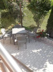 eine Terrasse mit Tisch, Stühlen und Blumen in der Unterkunft BiesCZADOWE miejsce in Lesko