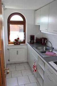 a small kitchen with a sink and a window at Ferienwohnung Weber Alpenglück in Lechbruck