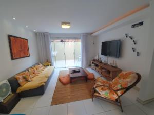 - un salon avec un canapé et une télévision dans l'établissement Casa De Búzios, à Búzios