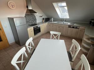 a kitchen with a white table and white chairs at Kleine Auszeit in Goslar