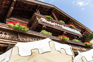 an old building with flowers on the roof at Romantik & Family Hotel Gardenia***S in Selva di Val Gardena