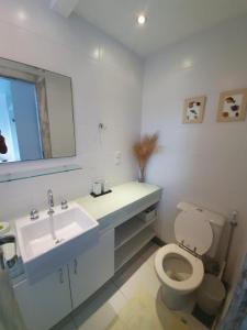 La salle de bains est pourvue d'un lavabo, de toilettes et d'un miroir. dans l'établissement Casa De Búzios, à Búzios
