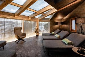 a living room with two couches and a chair at Romantik & Family Hotel Gardenia***S in Selva di Val Gardena