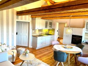 a living room with a table and a kitchen at Villa B das zauberhafte Chalet in Vetschau